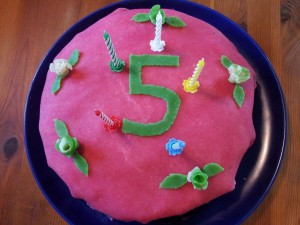 Bilden visar en blodsockervänlig prinsesstårta. Den är rosa med en stor grön femma på.
